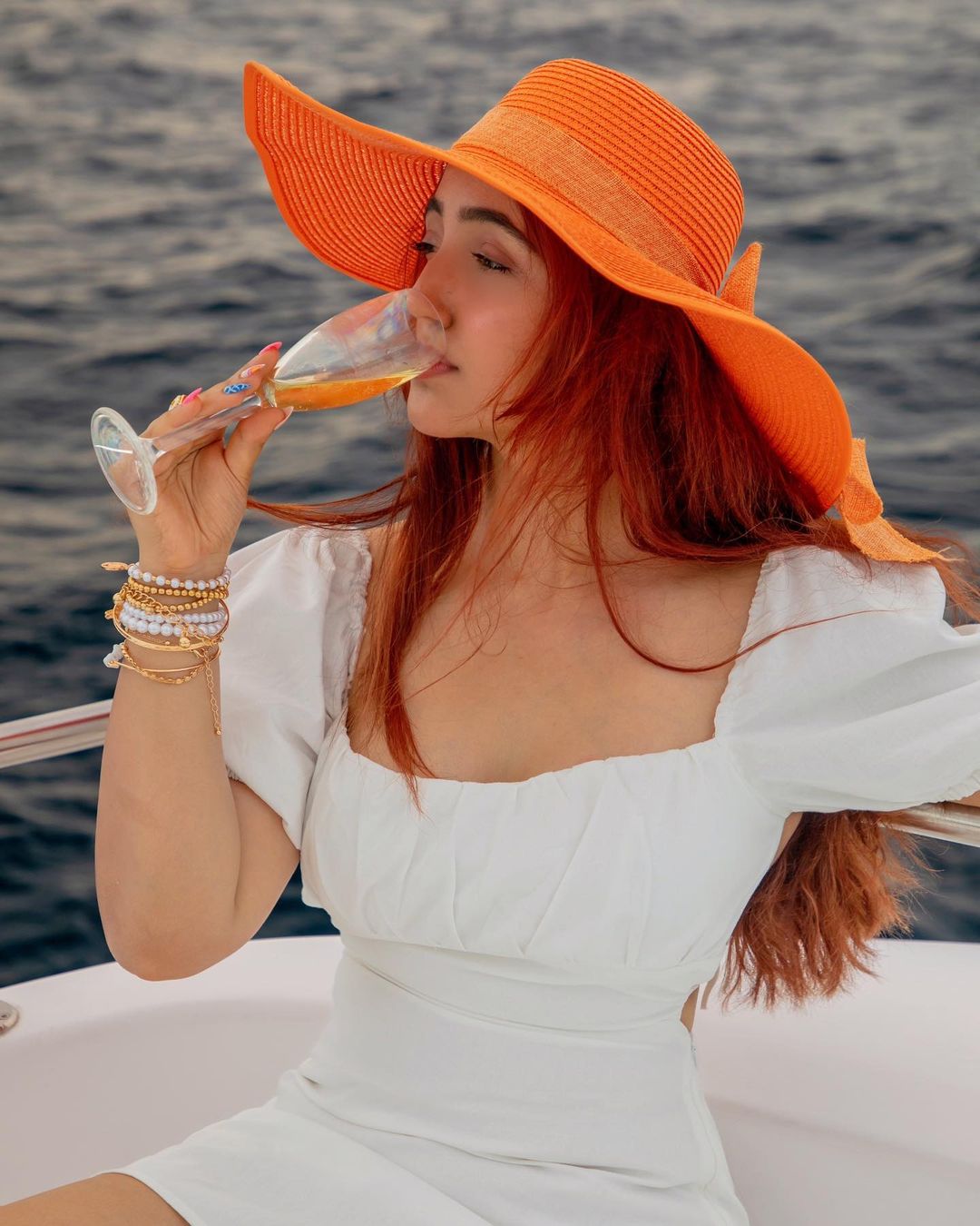 Ashnoor in white dress and orange hat